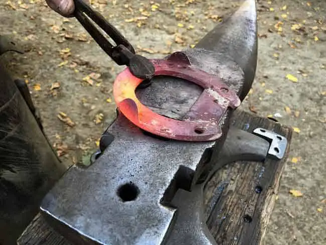 hammering the horseshoe into the right shape